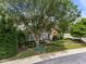 Charming brick home featuring mature landscaping, a well-manicured lawn, and a welcoming front porch at 12221 Orchardgrass Ln, Raleigh, NC 27614