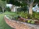 Well-manicured front yard with stone retaining wall and lush landscaping enhances curb appeal at 12221 Orchardgrass Ln, Raleigh, NC 27614