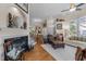 Spacious living room with marble fireplace, wooden floors, and seamless access to dining area at 12221 Orchardgrass Ln, Raleigh, NC 27614