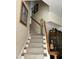 Carpeted staircase with wooden handrail and decorative accents at 12221 Orchardgrass Ln, Raleigh, NC 27614