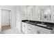 Bathroom featuring double sinks, white cabinetry, a shower, and marble-look tile at 123 Pony Gallop Ln, Clayton, NC 27520