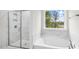 Bathroom featuring a glass-enclosed shower, and tub under a window overlooking the backyard at 123 Pony Gallop Ln, Clayton, NC 27520