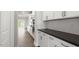 Modern kitchen featuring white cabinets, stainless steel appliances, and a long island with dark countertops at 123 Pony Gallop Ln, Clayton, NC 27520