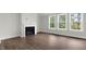 Bright living room with fireplace, hardwood floors, and large windows showcasing the outdoor view at 123 Pony Gallop Ln, Clayton, NC 27520