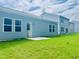 Well-maintained backyard with a concrete patio, lush green grass, and a view of the home's exterior at 124 N Keatts Winner Ct, Wilson's Mills, NC 27520