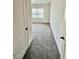 An open-concept bedroom offers plush gray carpeting and plenty of natural light from a well-placed window at 124 N Keatts Winner Ct, Wilson's Mills, NC 27520