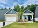 Attractive single-Gathering home with brick and blue siding, attached garage, well-kept lawn, and inviting curb appeal on a sunny day at 124 N Keatts Winner Ct, Wilson's Mills, NC 27520