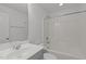 A pristine white bathroom featuring a shower-tub combo, toilet, and single sink at 127 Bowerbank Ln, Apex, NC 27539