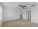 A bedroom with a ceiling fan and neutral carpeting, adjacent to a bathroom and closet at 127 Bowerbank Ln, Apex, NC 27539
