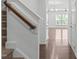 Hallway with hardwood floors and view into living space with chandelier at 127 Bowerbank Ln, Apex, NC 27539