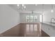 Open-concept living area with hardwood floors, large windows, and modern lighting at 127 Bowerbank Ln, Apex, NC 27539