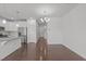 Open-concept living area with hardwood floors, view of kitchen, and modern lighting at 127 Bowerbank Ln, Apex, NC 27539