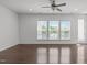 Bright living space featuring three large windows, ceiling fan, and hardwood floors at 127 Bowerbank Ln, Apex, NC 27539