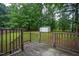 Spacious backyard with a wooden deck, shed, green grass, and mature trees at 129 Clark Ct, Youngsville, NC 27596