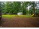 This backyard offers an outdoor storage shed, a playground, and is surrounded by trees at 129 Clark Ct, Youngsville, NC 27596