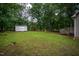 Large backyard with a shed, playground, green grass, mature trees, and wooden deck at 129 Clark Ct, Youngsville, NC 27596