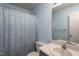 Bathroom with a shower/tub combo, marble countertop sink, white door and light blue walls at 129 Clark Ct, Youngsville, NC 27596