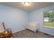 Bedroom with a white crib, wooden rocking chair, neutral carpet, and natural light from the window at 129 Clark Ct, Youngsville, NC 27596