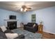 Comfortable living room featuring a fireplace, ceiling fan, and a window with natural light at 129 Clark Ct, Youngsville, NC 27596
