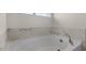 Bright bathroom featuring a marble tile accent wall and a soaking tub with elegant gold hardware at 135 Pony Gallop Ln, Clayton, NC 27520