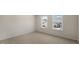 A bedroom with carpeted floors and two windows offering natural light at 135 Pony Gallop Ln, Clayton, NC 27520