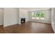 Well-lit living room with a cozy fireplace, multiple windows, and hardwood floors at 135 Pony Gallop Ln, Clayton, NC 27520