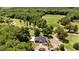 An aerial view of the golf course, putting green, clubhouse, and surrounding area with lush trees at 159 Clear Water Rd, Louisburg, NC 27549