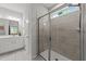 Modern bathroom features a tiled shower with glass door and bright vanity with a mirror at 159 Clear Water Rd, Louisburg, NC 27549