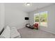 Neutral bedroom features a small bed, a white couch, and a window letting in natural light at 159 Clear Water Rd, Louisburg, NC 27549