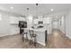 Bright kitchen with white cabinets, a large center island with seating, modern appliances, and wood-look floors at 159 Clear Water Rd, Louisburg, NC 27549