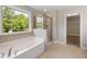 Bathroom with a soaking tub, glass shower, window and tile flooring at 1600 Drift Falls Ln, Wendell, NC 27591