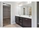 Double sink bathroom vanity with dark cabinets, neutral walls and access to a walk-in closet at 1600 Drift Falls Ln, Wendell, NC 27591