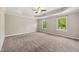 Large primary bedroom features two bright windows, carpet, trey ceiling and a ceiling fan at 1600 Drift Falls Ln, Wendell, NC 27591