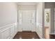 Welcoming entryway with paneled walls, wood floors and a white door at 1600 Drift Falls Ln, Wendell, NC 27591