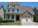 Charming home showcasing a welcoming front porch and convenient two-car garage at 1600 Drift Falls Ln, Wendell, NC 27591