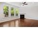 Well-lit open living room with hardwood floors and a corner fireplace at 1600 Drift Falls Ln, Wendell, NC 27591