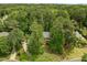Aerial view of home nestled among lush trees, offering privacy and natural beauty at 18 Acornridge Ct, Durham, NC 27707