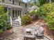 Backyard patio with stone pavers, comfortable seating, a fire pit and a view of the house and landscaped yard at 18 Acornridge Ct, Durham, NC 27707