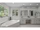 Bright bathroom featuring a soaking tub, double vanity, and neutral countertops at 18 Acornridge Ct, Durham, NC 27707