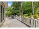 Back deck featuring a grill and white railing, perfect for outdoor cooking and entertaining with wooded backdrop at 18 Acornridge Ct, Durham, NC 27707