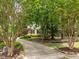 Long paved driveway leading to a two-story home surrounded by mature trees and meticulous landscaping at 18 Acornridge Ct, Durham, NC 27707