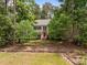 Traditional two-story home with black shutters and a vibrant red front door, nestled among mature trees at 18 Acornridge Ct, Durham, NC 27707