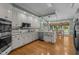 Bright kitchen boasts white cabinetry, stainless appliances, granite counters and hardwood floors at 18 Acornridge Ct, Durham, NC 27707