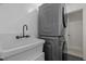 Laundry room with a utility sink and stacked washer and dryer at 18 Acornridge Ct, Durham, NC 27707