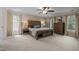 A spacious main bedroom featuring a large bed, wood furniture, neutral carpet, curtains and natural light at 18 Acornridge Ct, Durham, NC 27707