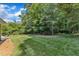 Lush backyard with mature trees and green grass, creating a private and serene outdoor space at 1920 Hillock Dr, Raleigh, NC 27612