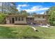 Backyard of the house features a brick and siding exterior, trees, and a seating area at 1920 Hillock Dr, Raleigh, NC 27612
