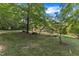 Tranquil backyard featuring mature trees, lush greenery, and a glimpse of the home's exterior at 1920 Hillock Dr, Raleigh, NC 27612