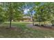 Secluded backyard with lush greenery, mature trees, and partial view of the home's screened-in porch at 1920 Hillock Dr, Raleigh, NC 27612