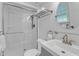 Bright white bathroom features a glass shower, a towel rack, and a large, round mirror at 1920 Hillock Dr, Raleigh, NC 27612